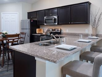 a kitchen with granite counter tops and a large island with a sink