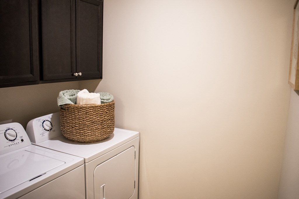 a laundry room with a washer and dryer and a basket on the top
