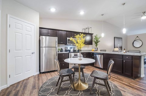 a kitchen with stainless steel appliances and a table with chairs