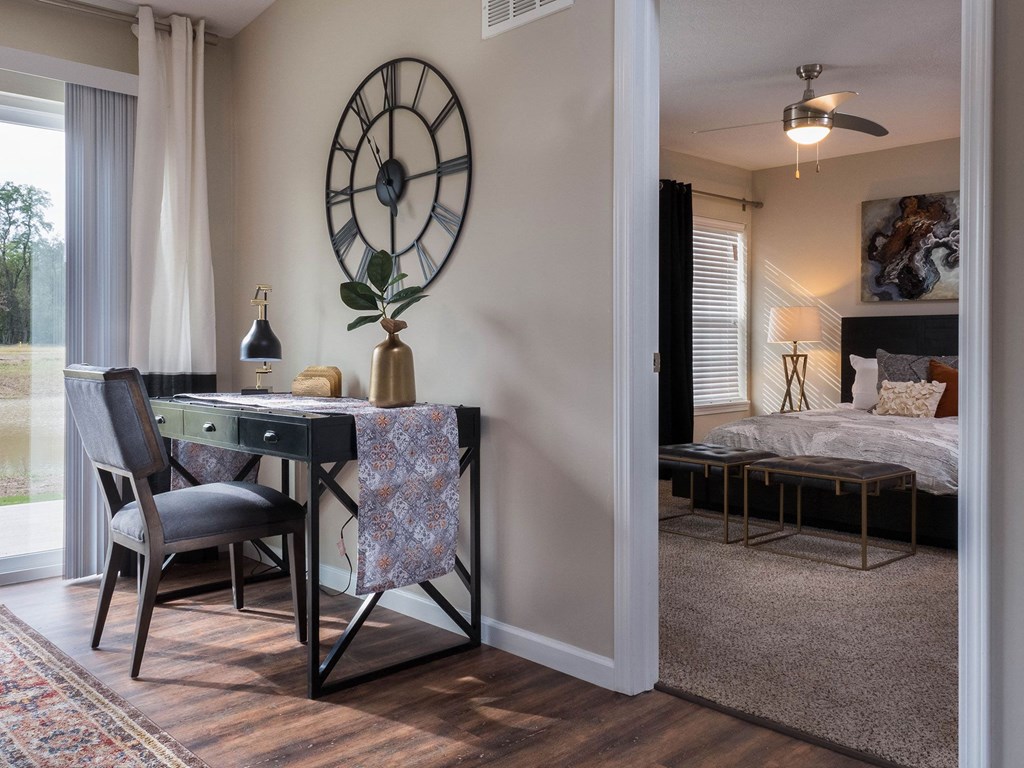 a bedroom with a desk and a large clock on the wall