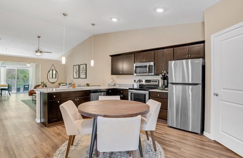 a kitchen and dining room with stainless steel appliances and a wooden table