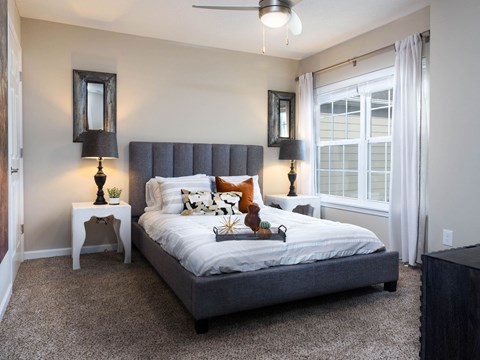 a bedroom with a bed and a large window