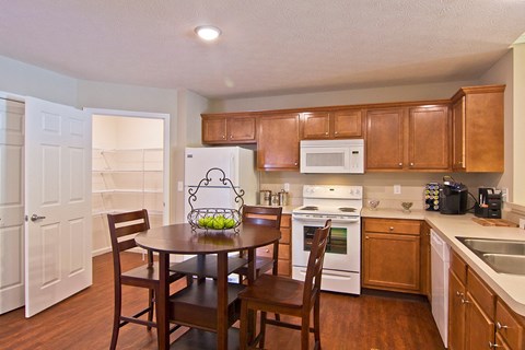 a kitchen with wooden cabinets and a table with chairs