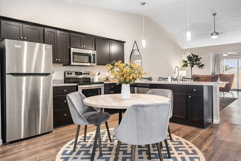 a kitchen with stainless steel appliances and a round table with chairs