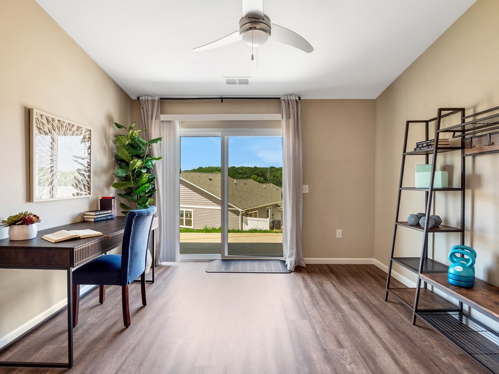an office with a sliding glass door and a view of a house
