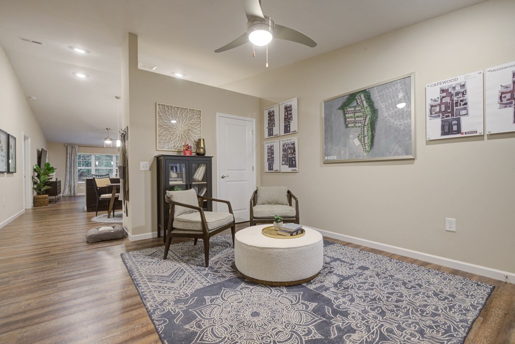 a living room with a ceiling fan and a rug