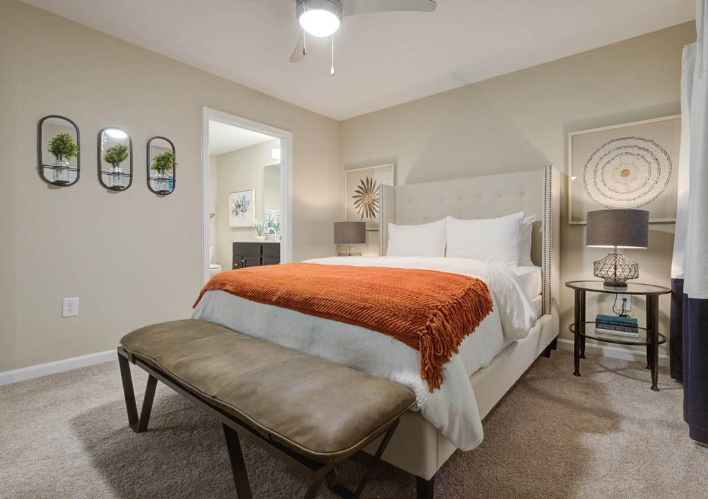 a bedroom with a bed and a bench in front of a closet