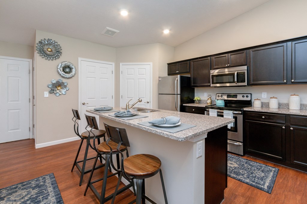 a kitchen with a large island with three bar stools