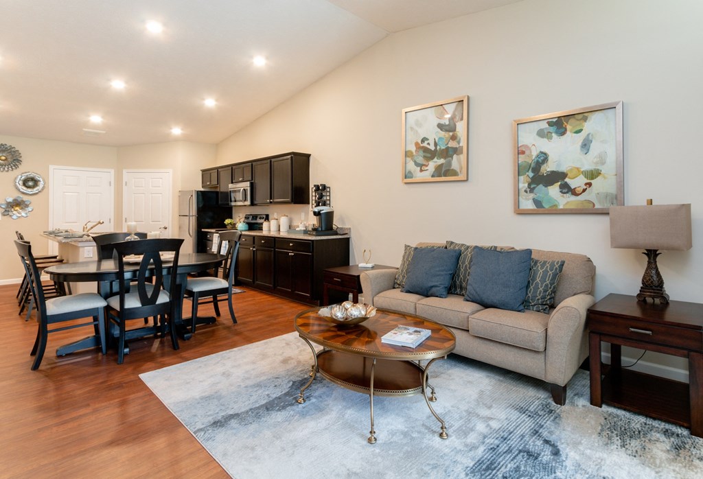 a living room with a couch and a table and a kitchen