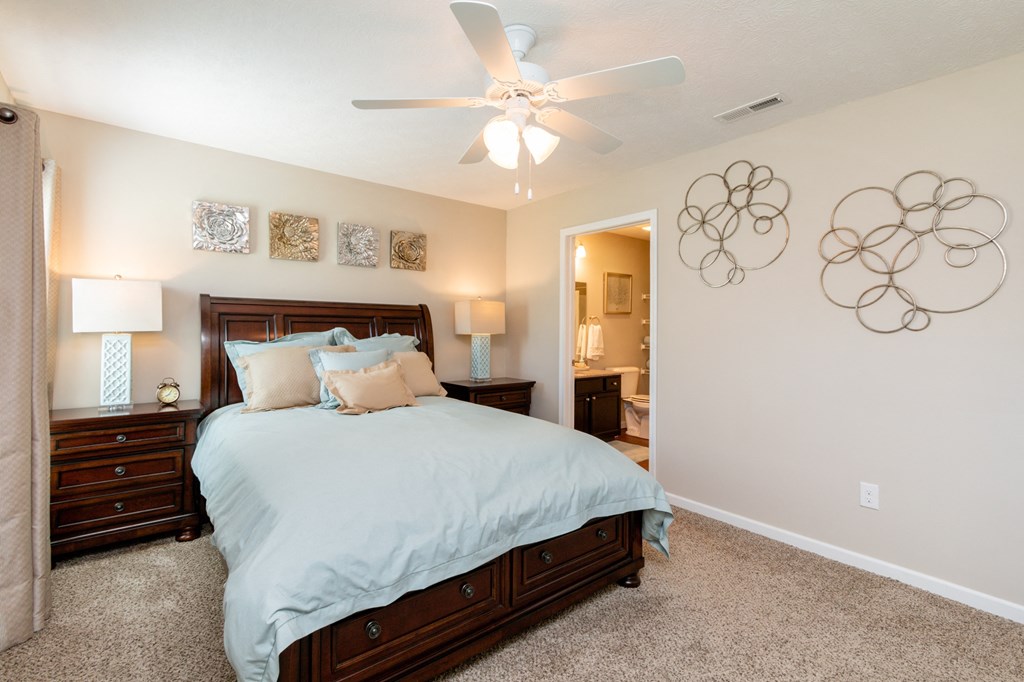 a bedroom with a large bed and a ceiling fan