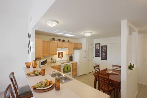 a view of a kitchen and dining room with a table and chairs