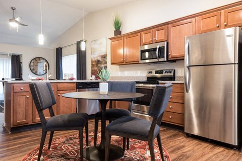 a kitchen with stainless steel appliances and a table with chairs