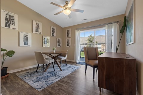 A dining room with a table and chairs.