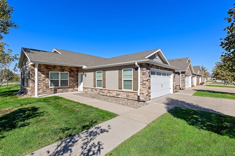 A house with a stone wall and a garage door.