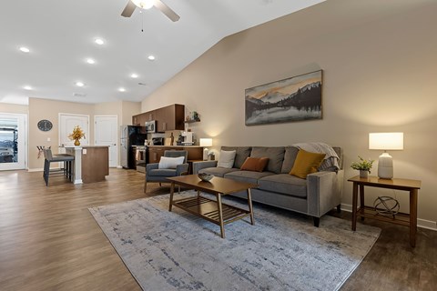 A living room with a grey couch, a coffee table, and a painting on the wall.