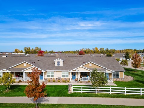 A row of houses with a white picket fence in front.