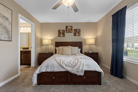 A bedroom with a large bed and a ceiling fan.