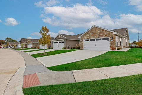 A house with a driveway and a tree in front of it.