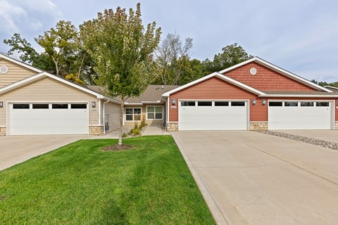 A house with a red roof and two garages.