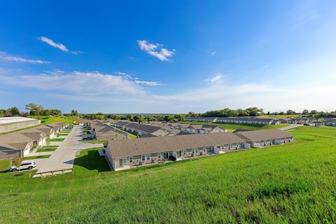 A row of houses with a grassy field in front.