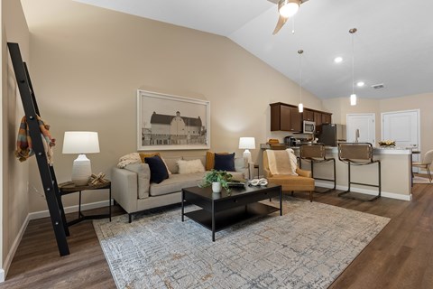 A living room with a couch, chairs, and a coffee table.