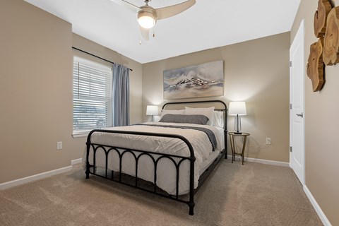 A bedroom with a large bed and a ceiling fan.
