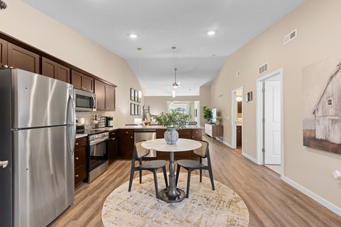 A kitchen with a refrigerator, oven, and microwave.