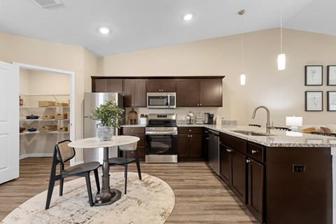 A kitchen with brown cabinets and a white table.