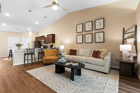 A living room with a white couch and a rug on the floor.