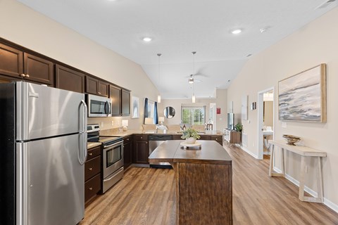 A modern kitchen with a wooden island and stainless steel appliances.