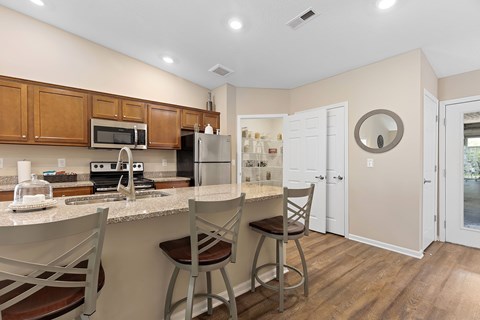 A kitchen with a bar stool and a counter.