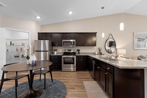 A modern kitchen with dark brown cabinets and stainless steel appliances.