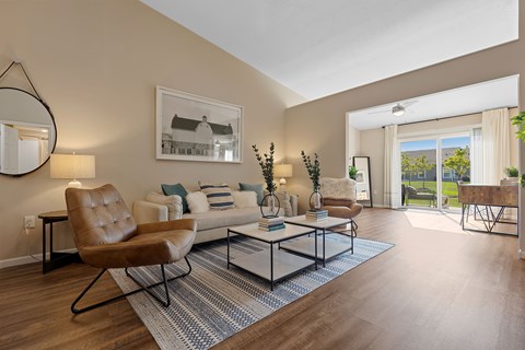 A living room with a brown leather chair and a glass coffee table.