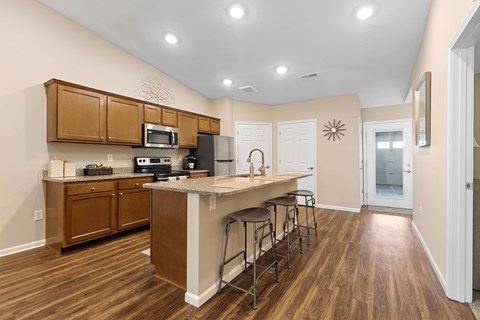 A kitchen with wooden cabinets and a white island.