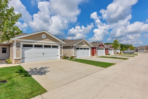 A row of houses with garages and driveways.