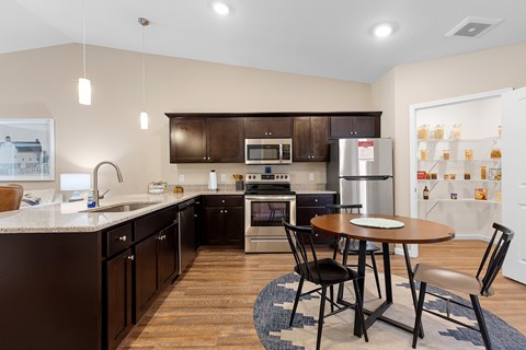 A kitchen with a table and chairs in the middle of the room.