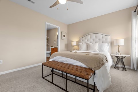 A bedroom with a large bed and a ceiling fan.
