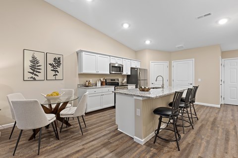 A kitchen with a table and chairs.