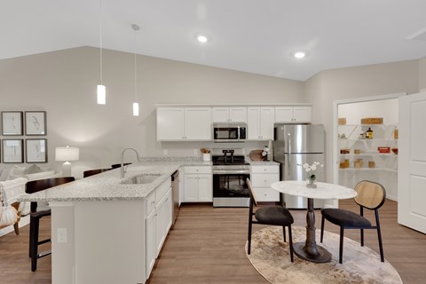 A modern kitchen with white cabinets and a marble island.