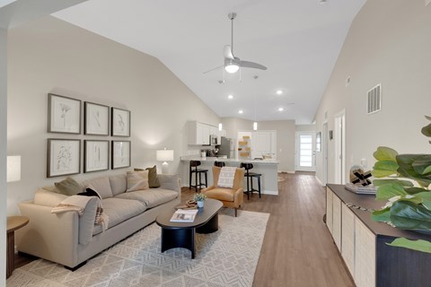 A living room with a couch, coffee table, and pictures on the wall.