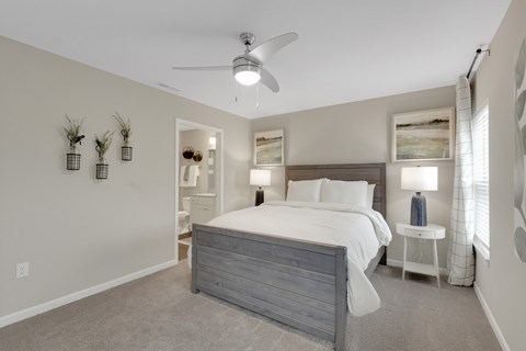 A bedroom with a large bed and a ceiling fan.