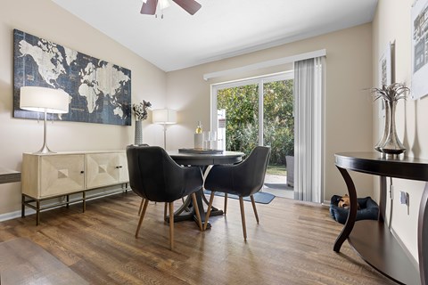 A room with a table, chairs and a painting on the wall.
