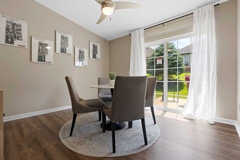 A dining room with a table and chairs.