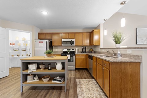 A kitchen with wooden cabinets and a grey island.