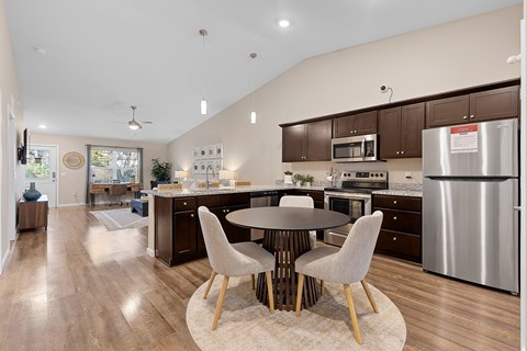A modern kitchen with a large island and a dining table set for four.