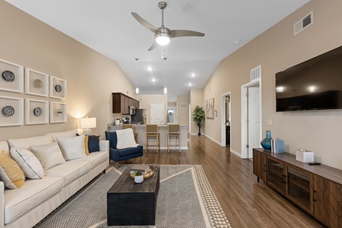 A living room with a white couch and a ceiling fan.