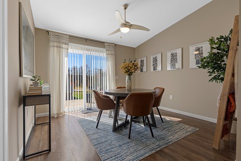 A dining room with a table and chairs.