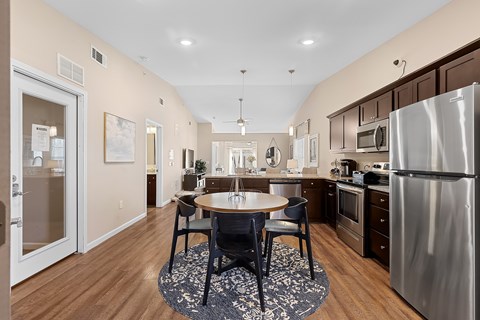 A kitchen with a table and chairs in the middle of the room.