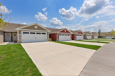 A row of houses with garages and driveways.