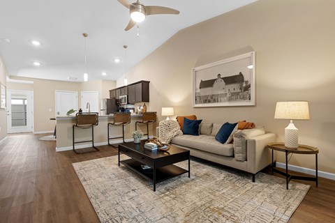 A living room with a couch, a coffee table, and a ceiling fan.